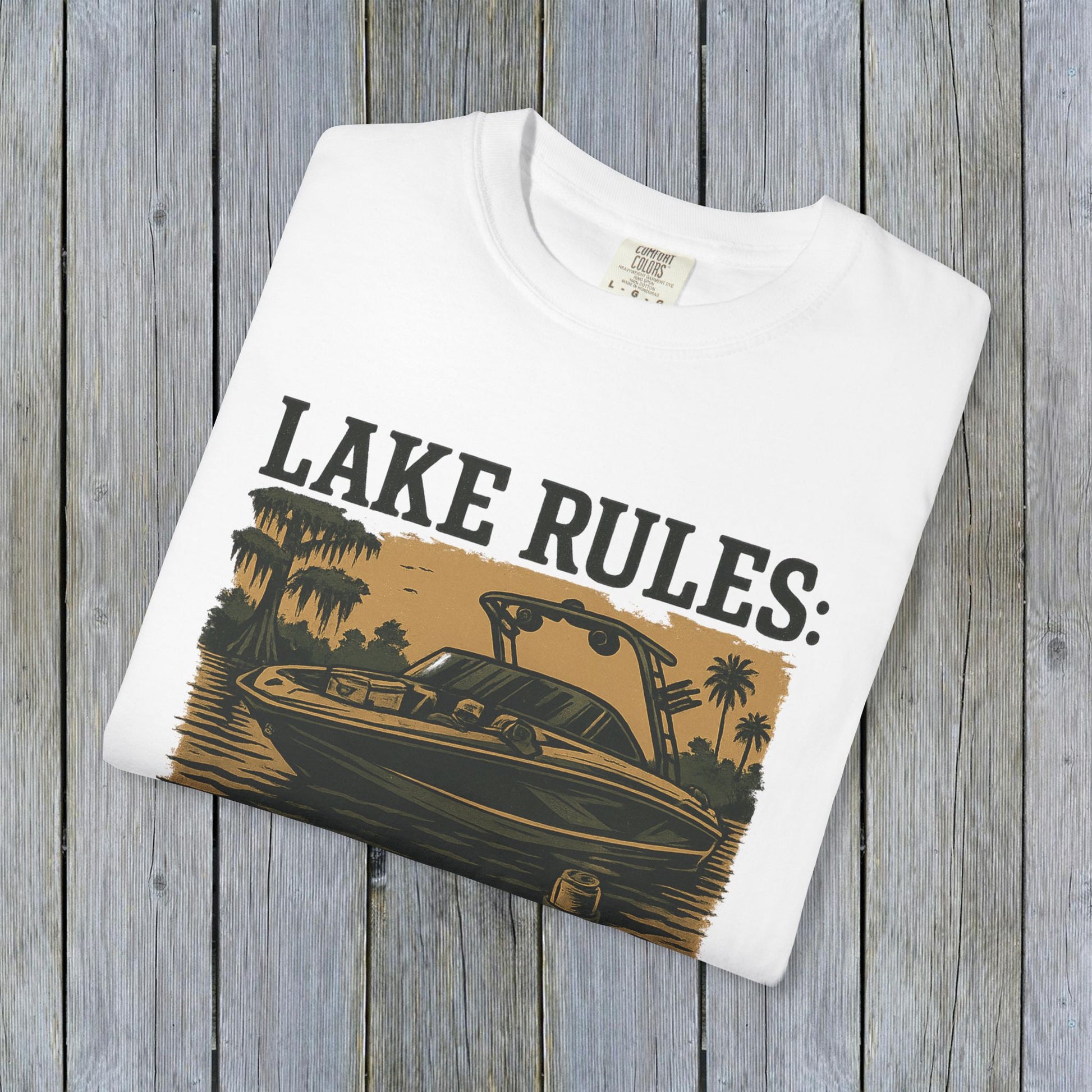 Close-up of the folded Unisex Garment-Dyed Lake Rules Tee featuring a vintage-style print of a boat, emphasizing the unique garment-dyed fabric.
