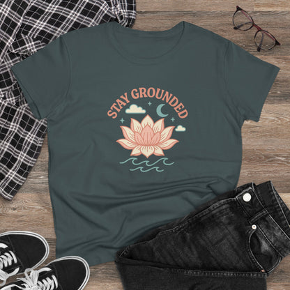 Stay Grounded Spiritual Tee with a lotus graphic styled on a flat lay, paired with black jeans, ideal for festival fashion.