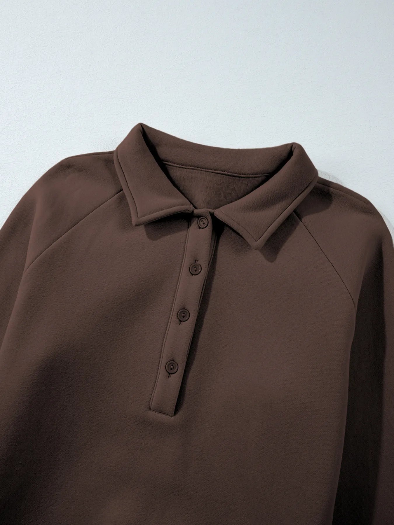 Close-up of the collar of the Trendsi Collared Sweatshirt from the Two-Piece Active Set, showcasing button details and soft fabric texture.