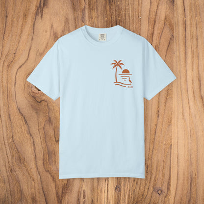 Unisex Sunset Palm Tree T-Shirt in light blue showcasing a palm tree and sun graphic, perfect for summer outings.