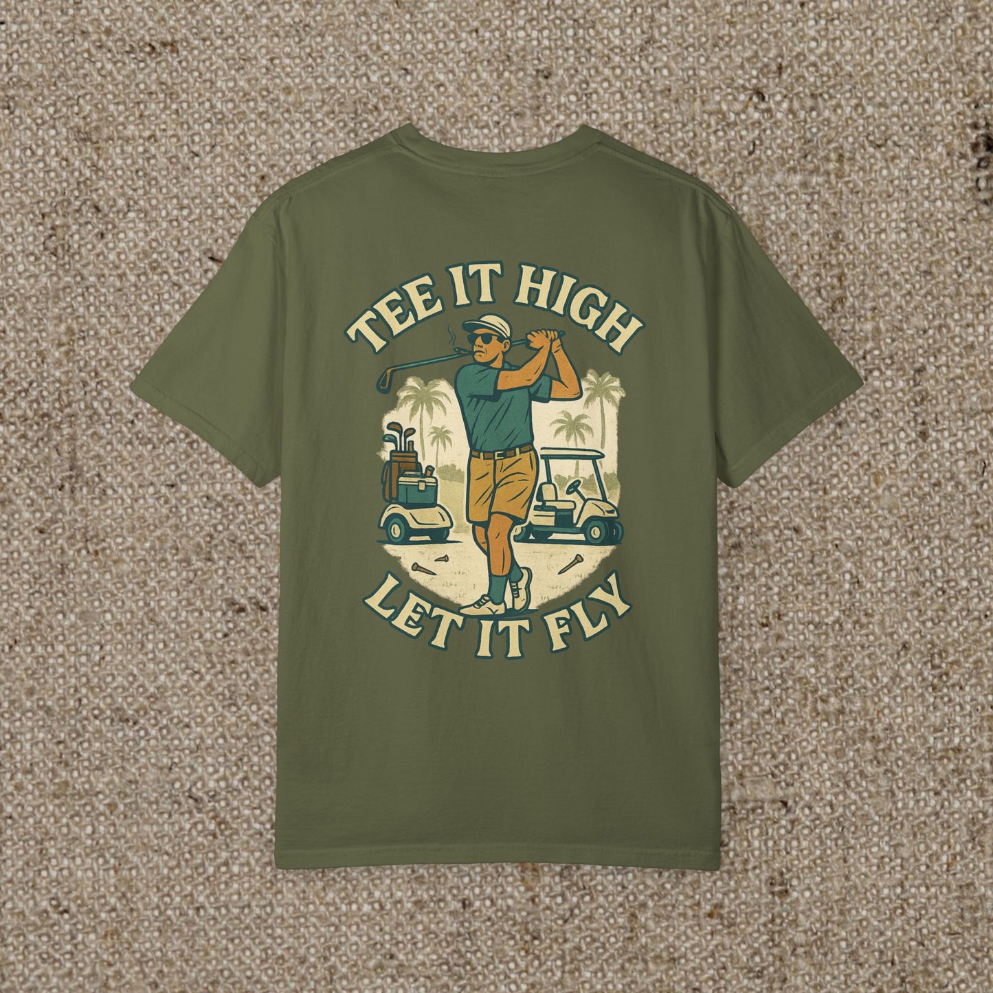 Tee It High Let It Fly Graphic Tee showcasing a golfer in action with a tropical background, perfect for golf enthusiasts.