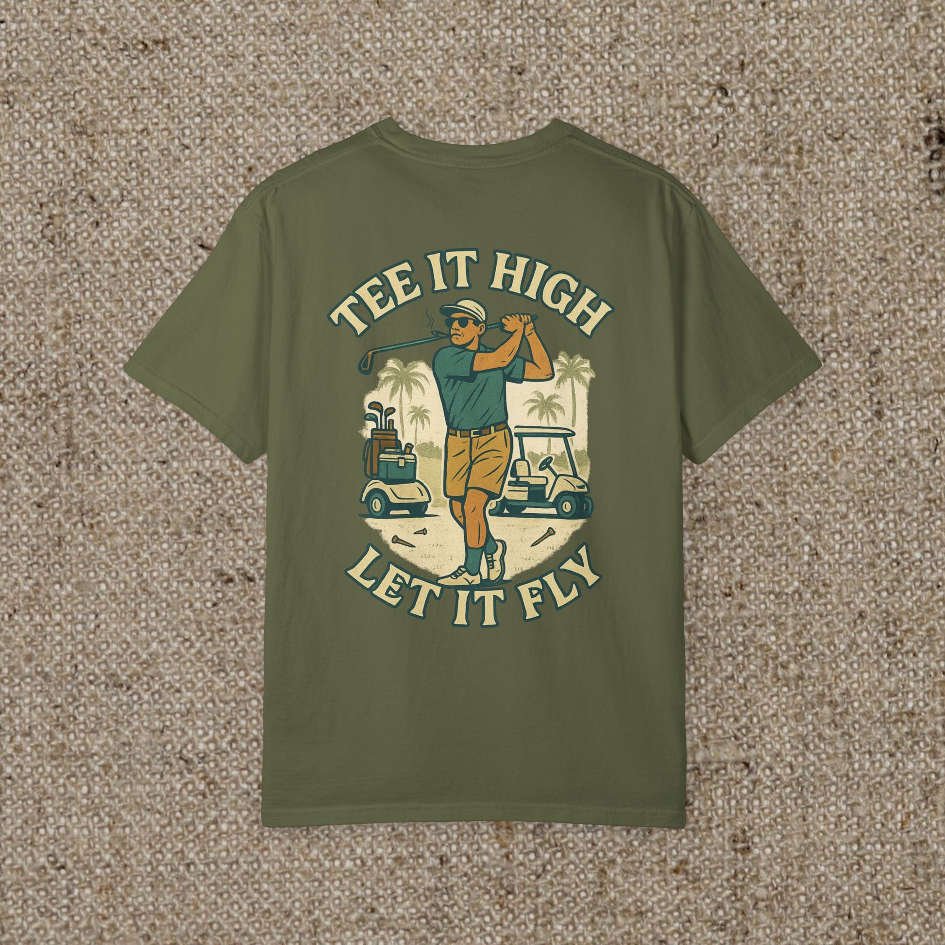 Tee It High Let It Fly Graphic Tee showcasing a golfer in action with a tropical background, perfect for golf enthusiasts.