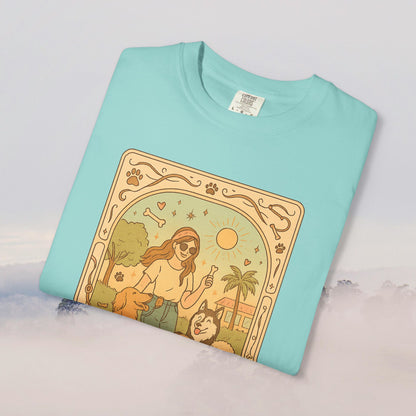 Animal Lover Tarot Tee displayed in teal color, showcasing a whimsical design featuring a woman with her pets surrounded by tropical elements, made from soft 100% cotton for comfort.