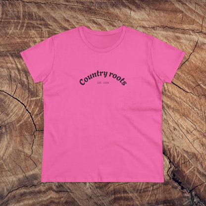 Stylish pink Country Roots Cowgirl Tee on a wooden background, featuring the slogan 'Country roots EST 1984'. Perfect for casual everyday wear.