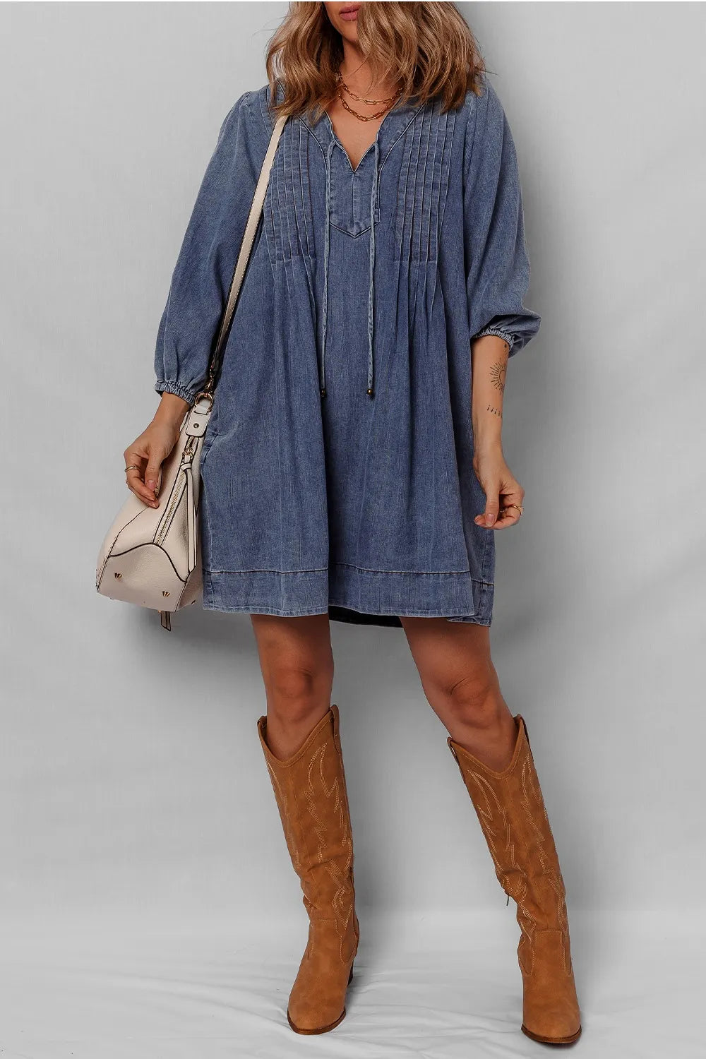 Fashionable model in a Tie Neck Long Sleeve Mini Denim Dress, posing elegantly with a stylish handbag, perfect for a casual outing.