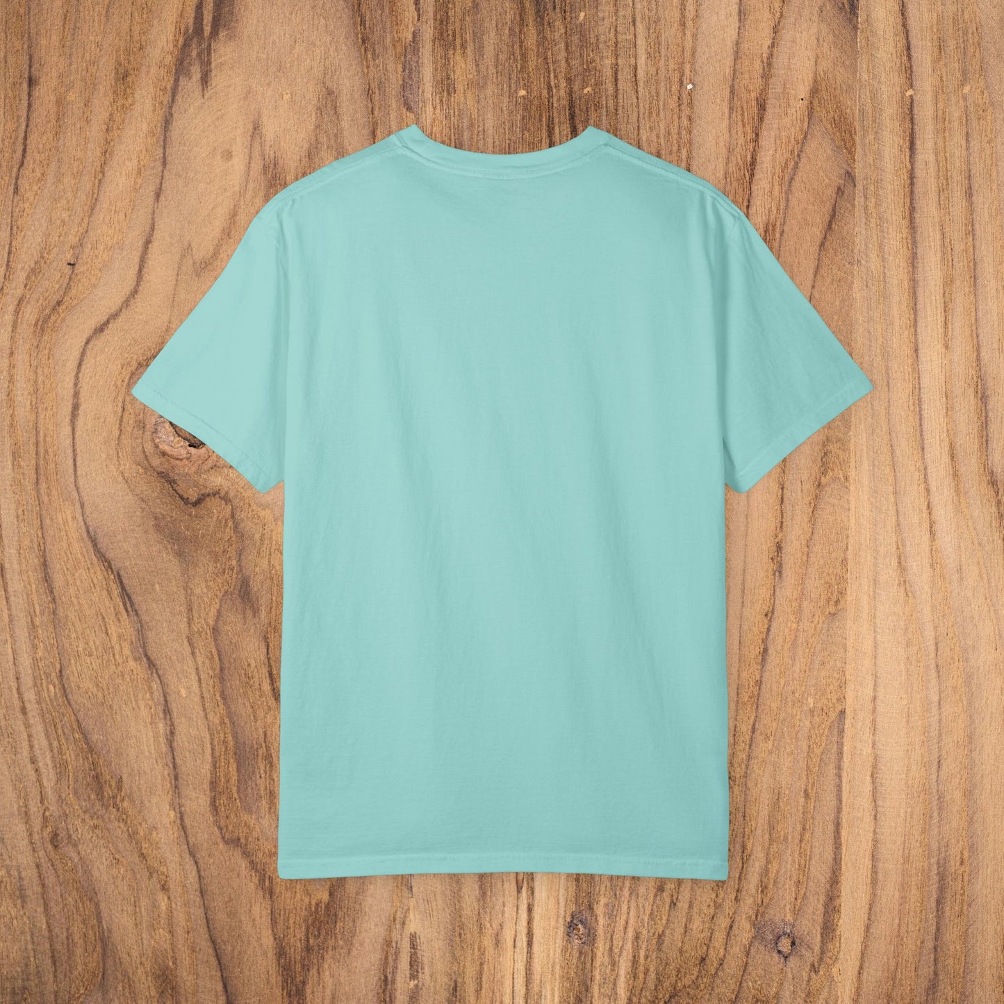 Back view of the Unisex Sunset Palm Tree T-Shirt in a soft aqua color, showcasing the comfortable garment-dyed fabric.