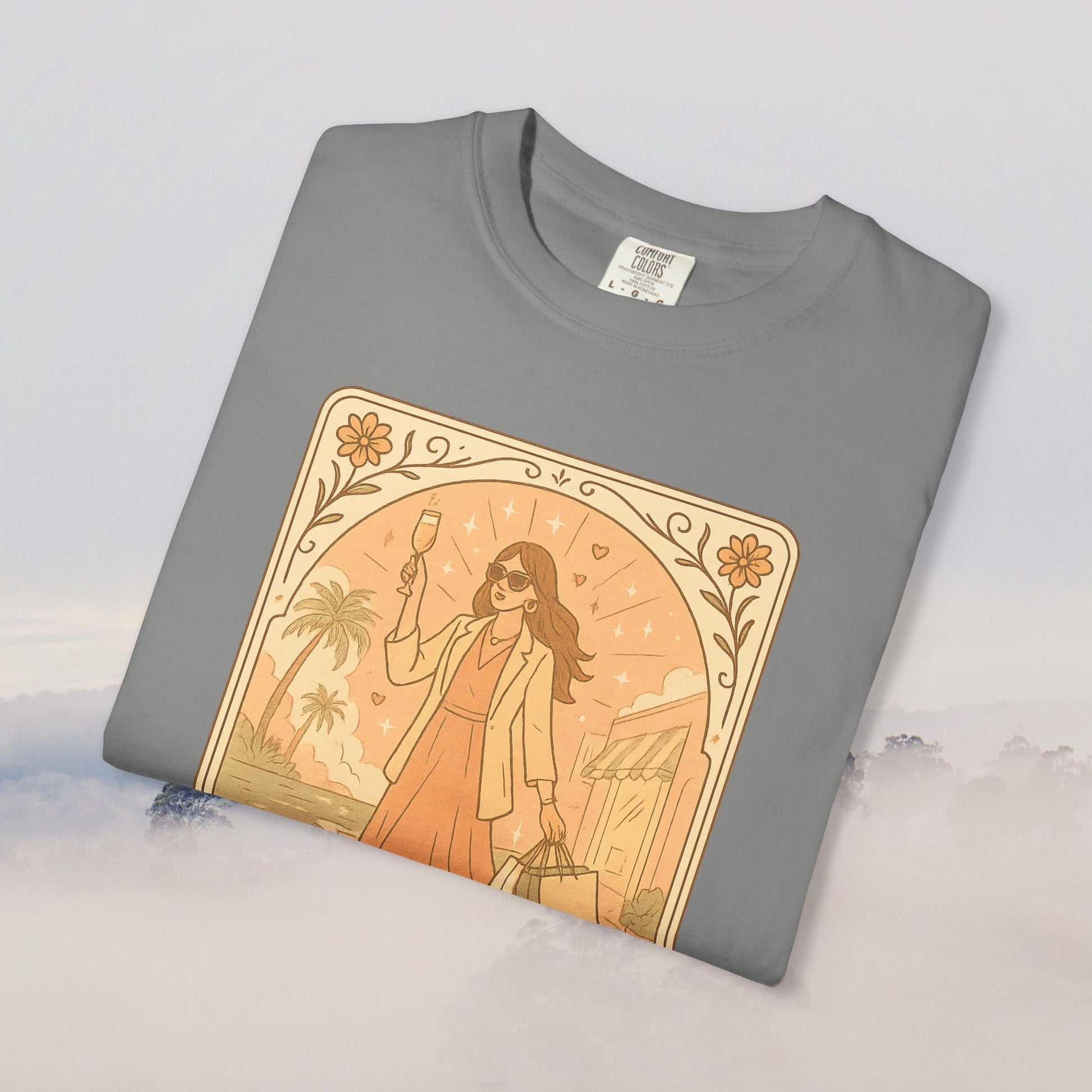 Brunch Babe Tarot Graphic Tee in gray color, featuring a stylish design with a woman holding a glass and shopping bags, made of 100% cotton for comfort, available in sizes S to 4XL.
