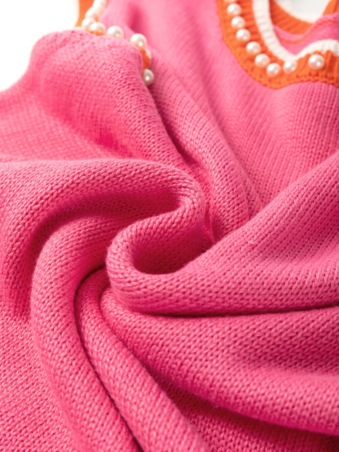 Attention to detail in the Stylish Contrast Trim Pearl Detail Sweater Tank Top, highlighting the soft pink fabric and stylish pearl embellishments.