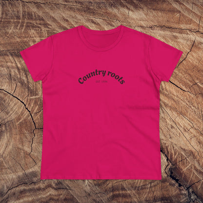 Vibrant fuchsia Country Roots Cowgirl Tee showcasing 'Country roots EST 1984' on a rustic wooden surface. Ideal choice for stylish everyday attire.