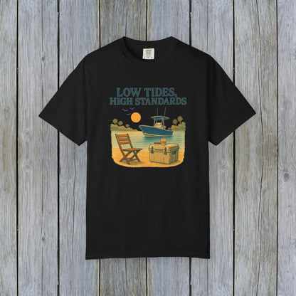 Garment-Dyed Low Tides High Standards T-Shirt in black, featuring a relaxing beach scene with a chair and boat. Made from soft 100% US cotton, available in sizes S-4XL.
