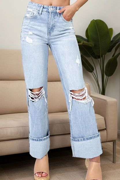 Trendy Distressed High Waist Jeans with Pockets - Slightly Stretchy Comfort Fit showcased in a modern living room setting. The jeans feature a distressed look and a fashionable high waist design, ideal for casual and trendy outfits.