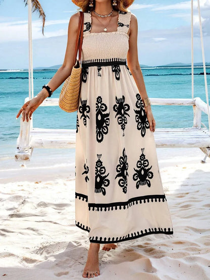 Trendsi Smocked Printed Maxi Dress with Wide Straps - Elegant Opaque, Non-Stretch Design featuring a woman in a flowy beige maxi dress with black designs, posing at a beach swing, highlighting the casual summer style.
