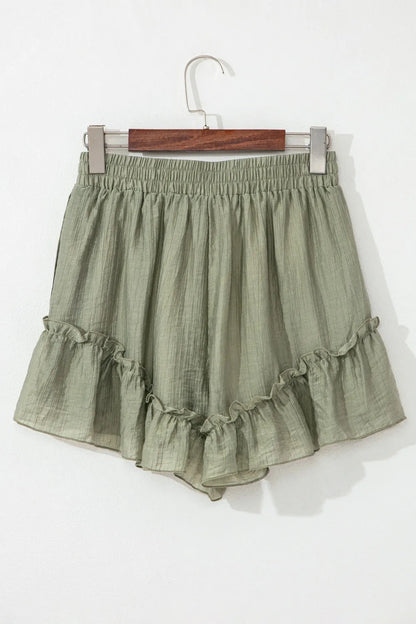 Back view of the Textured Tie Waist Ruffle Hem Shorts in olive green, featuring a loose, comfortable fit and playful ruffle design.