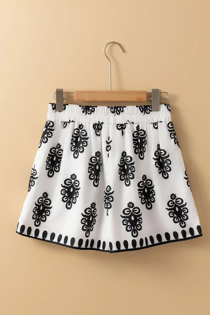 Tied Printed Shorts hanging on a wooden hanger, highlighting their trendy black and white design, a must-have addition to your summer wardrobe.