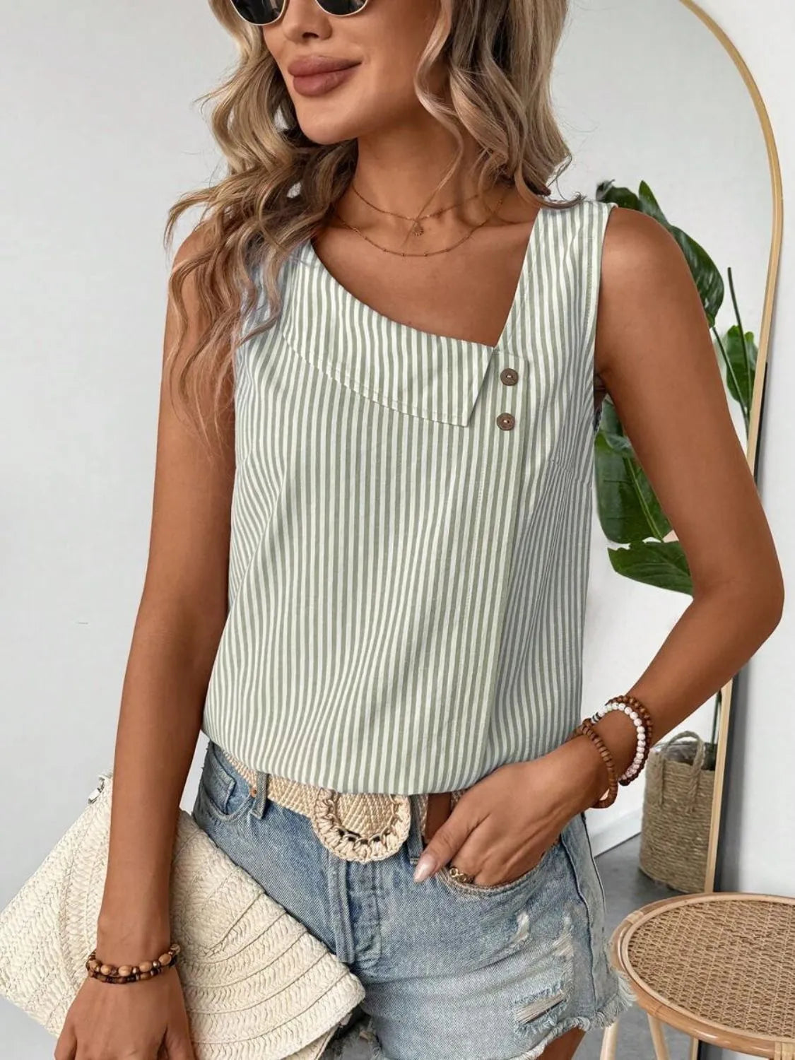 Casual outfit featuring the Asymmetrical Striped Tank with Decorative Buttons for Women, highlighting its chic design paired with shorts.