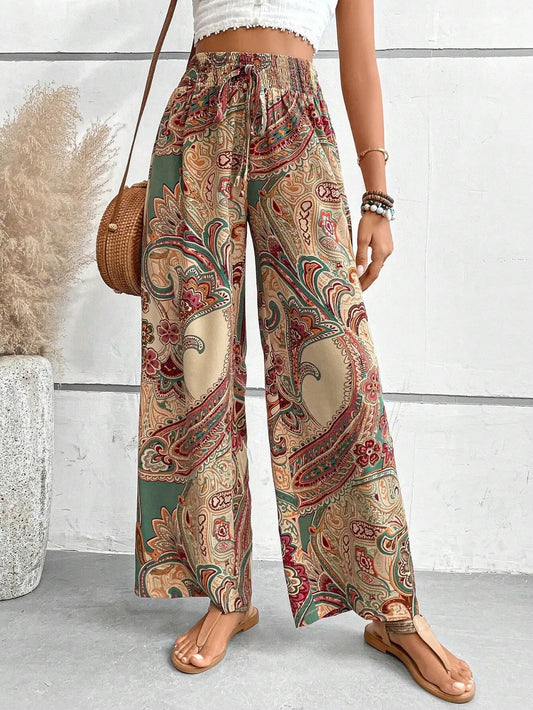 Trendy Printed Wide Leg Pants with Tied Detail - Model wearing stylish, 100% opaque polyester pants featuring a vibrant paisley print, ideal for every occasion.