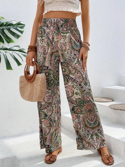 Trendy Printed Wide Leg Pants with Tied Detail, flaunting an eye-catching paisley pattern and paired with a light crop top and a fashionable straw bag, suitable for any occasion.