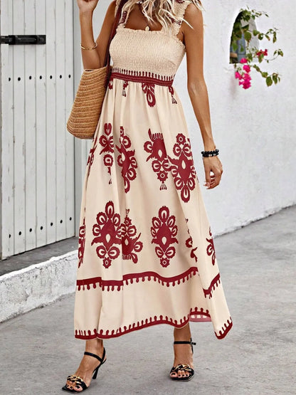 Trendsi Smocked Printed Maxi Dress with Wide Straps - Elegant Opaque, Non-Stretch Design, styled with a straw bag in a charming outdoor setting.