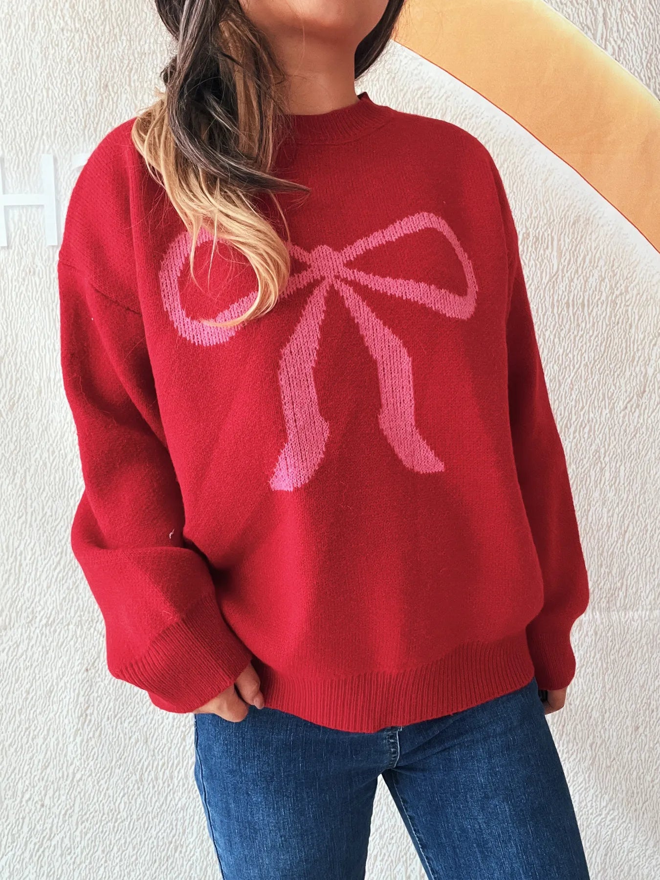 Stylish Bow Pattern Casual Long Sleeve Sweater for Effortless Everyday Wear in red, featuring a large bow design, styled with blue jeans.