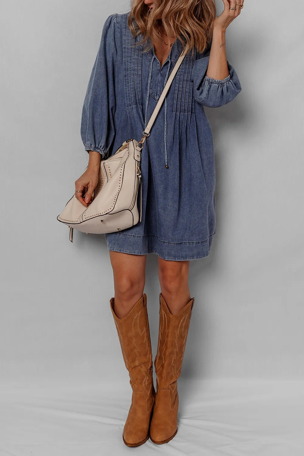 Stylish Tie Neck Long Sleeve Mini Denim Dress worn with cowboy boots and a handbag, perfect for a casual day out.