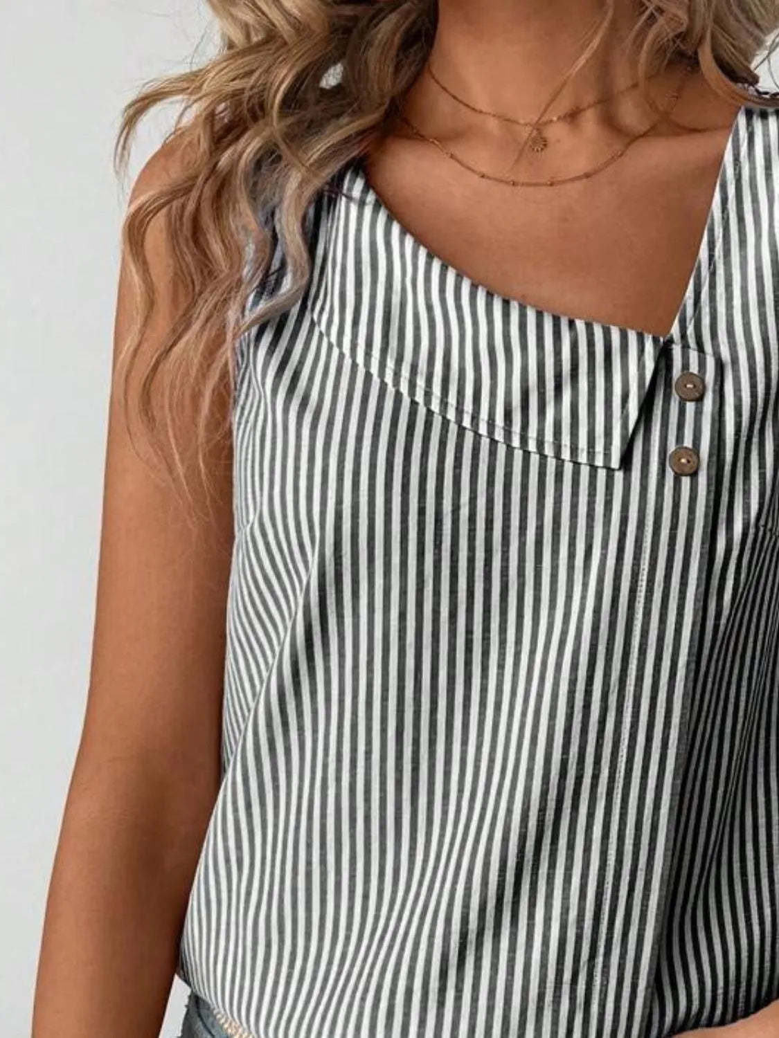 Detailed shot of the Asymmetrical Striped Tank with Decorative Buttons for Women, emphasizing the chic striped pattern and relaxed fit, crafted from 100% polyester.