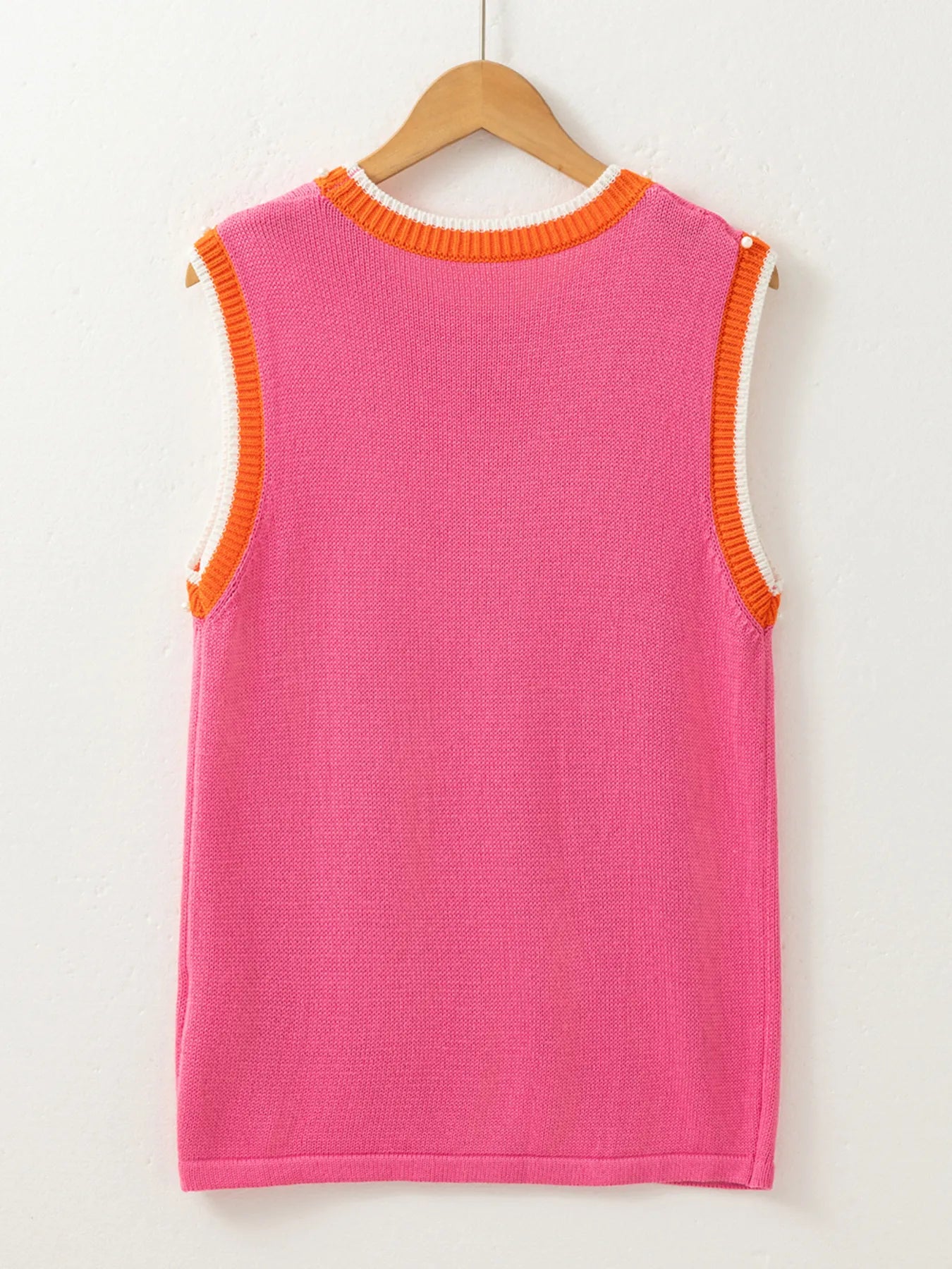 Back view of the Stylish Contrast Trim Pearl Detail Sweater Tank Top on a hanger, showcasing its bright pink color and unique design elements, ideal for a stylish summer wardrobe.