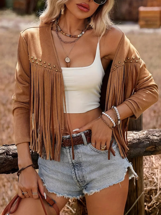 Close-up view of the Trendy Fringe Studded Open Front Jacket, highlighting the fringe and studded design, worn with a crop top and denim shorts, set against a natural background.
