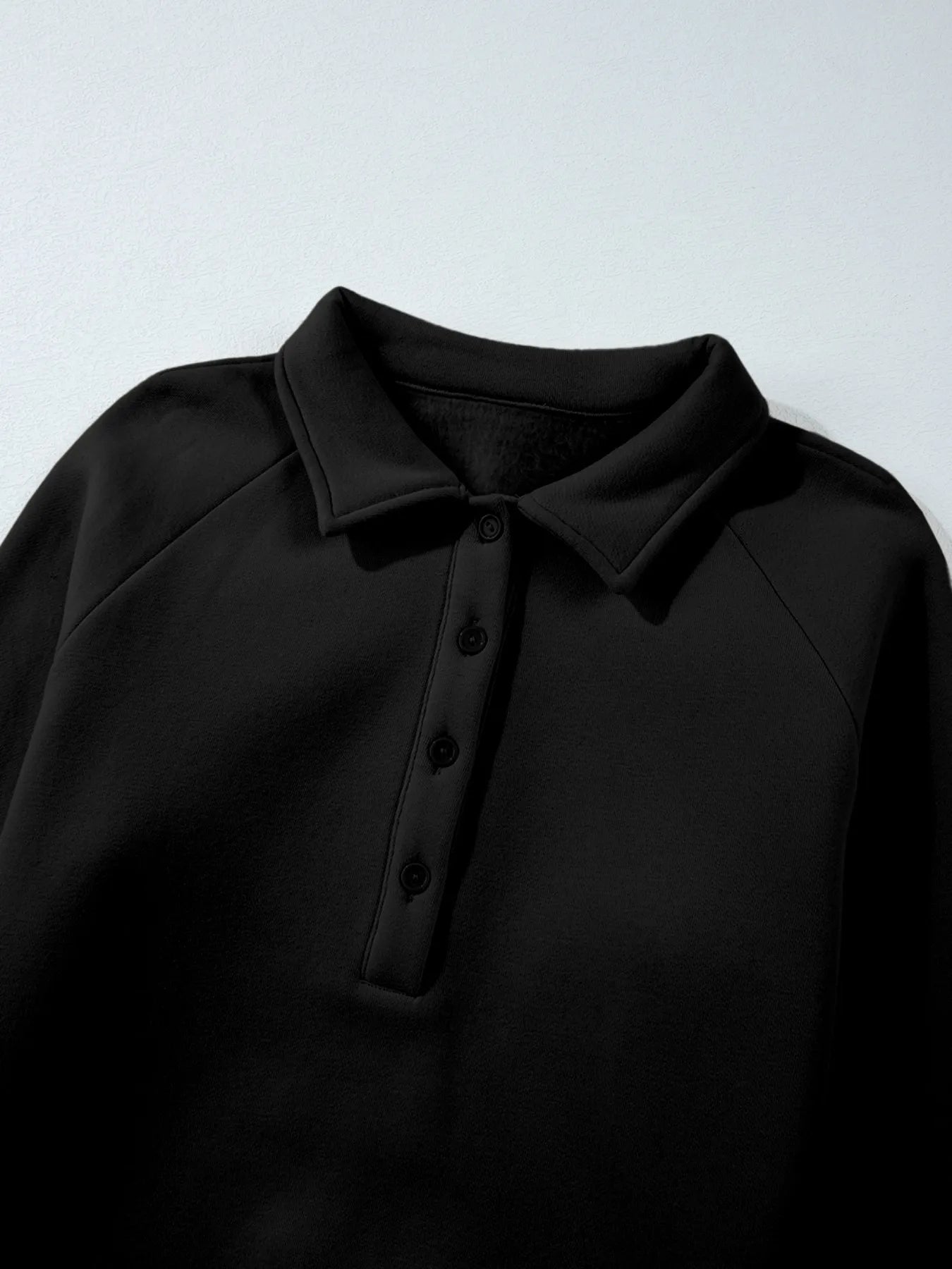 Close-up of the collared sweatshirt from the Trendsi Collared Sweatshirt & High Waist Pants Two-Piece Active Set, emphasizing the button detail and fabric texture.