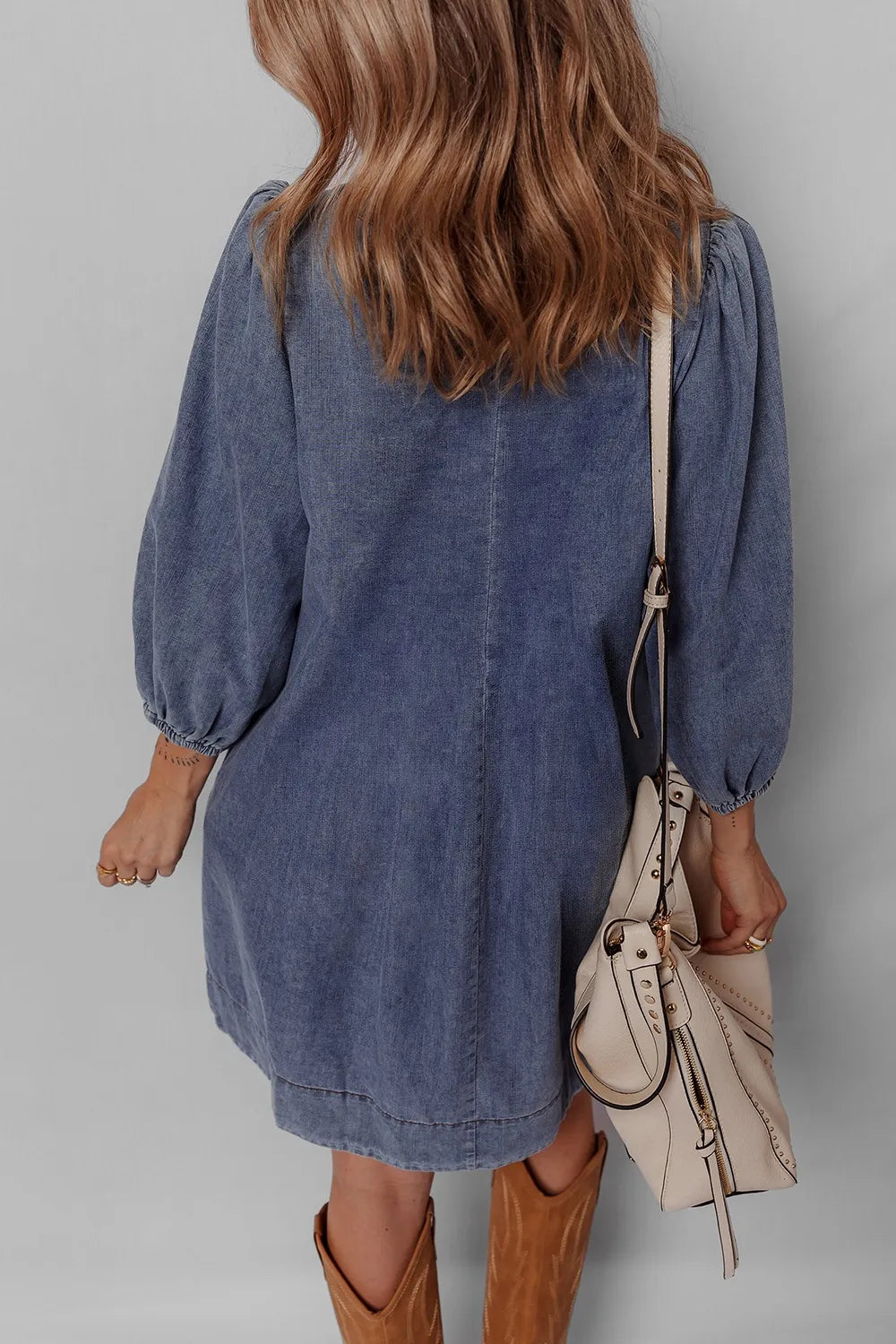 Back view of the Tie Neck Long Sleeve Mini Denim Dress, highlighting its relaxed fit and soft denim fabric.