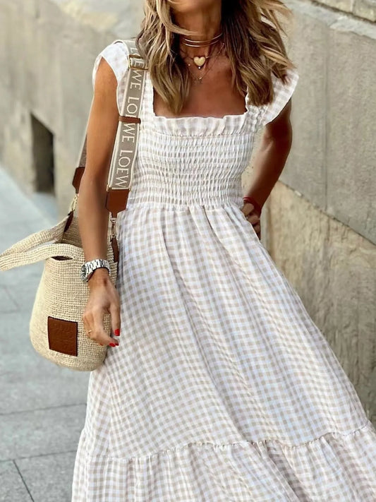 Chic female model in a Gingham Maxi Dress with Ruffle Straps, Smocked Bodice & Tiered Design by Trendsi, strutting her style with a textured bag on the street.